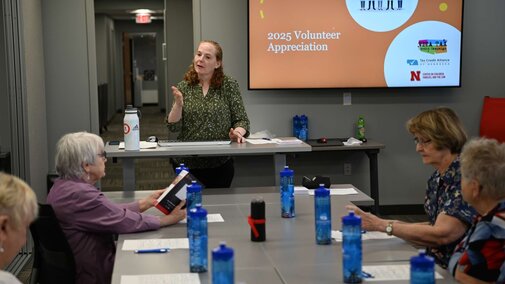 Katharina Stokes speaking to a room full of VITA volunteers. 